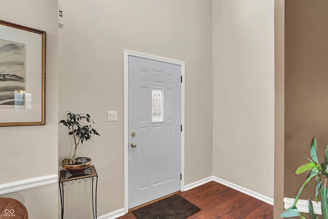 foyer entrance featuring dark wood-style flooring and baseboards