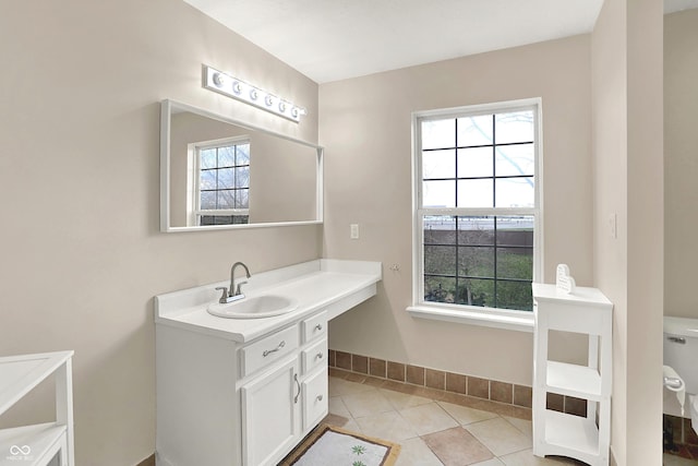 bathroom featuring toilet, tile patterned floors, vanity, and baseboards