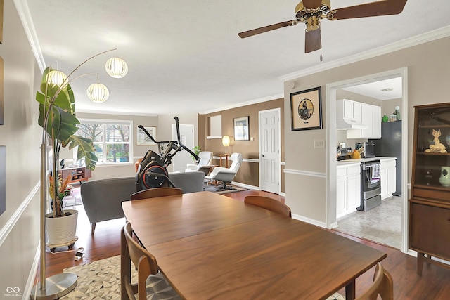 dining space featuring crown molding, light wood-type flooring, and a ceiling fan