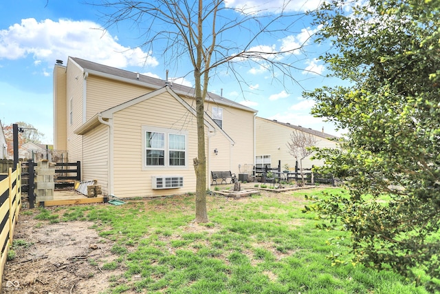 back of house with a fenced backyard, a lawn, and a chimney