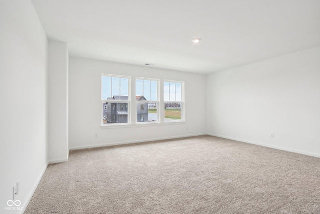 carpeted spare room with baseboards