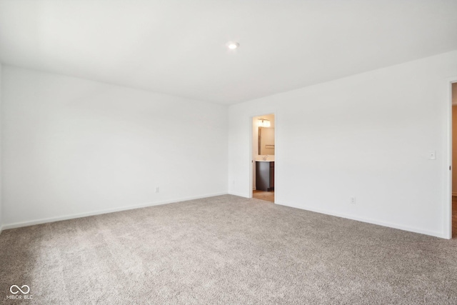 spare room featuring baseboards and light carpet