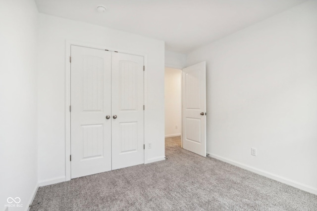 unfurnished bedroom featuring carpet, a closet, and baseboards