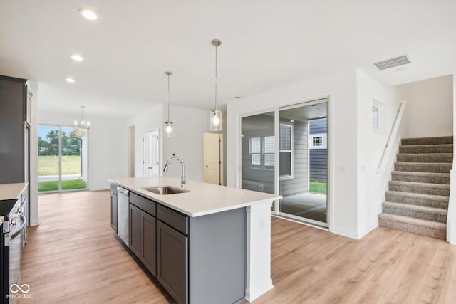 kitchen with visible vents, stainless steel appliances, a sink, light countertops, and light wood-style floors