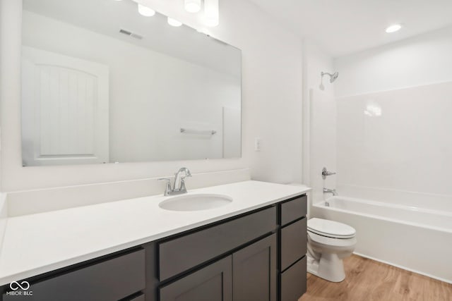 bathroom featuring visible vents, toilet, bathtub / shower combination, wood finished floors, and vanity