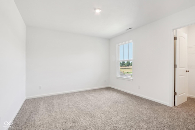 carpeted empty room featuring visible vents and baseboards