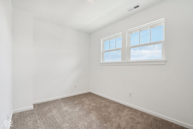 empty room featuring visible vents, baseboards, and carpet