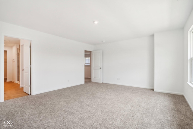 carpeted empty room featuring baseboards