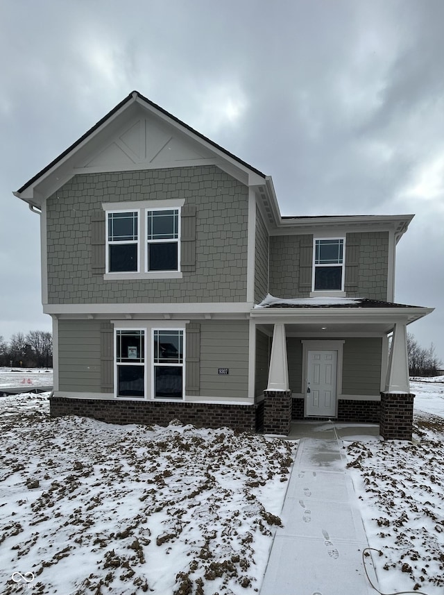 view of front facade featuring brick siding and covered porch