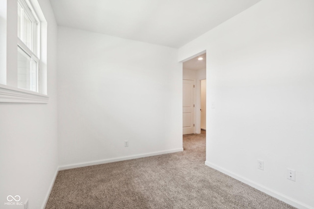 carpeted spare room featuring baseboards