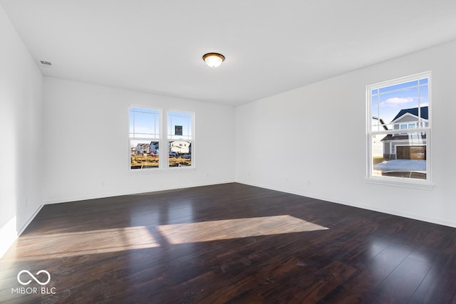 empty room with dark wood finished floors and baseboards