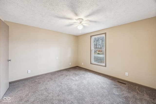 carpeted empty room featuring a textured ceiling, a ceiling fan, visible vents, and baseboards