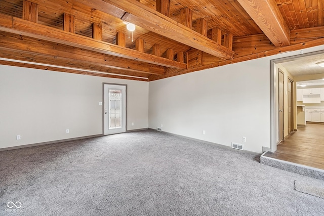 carpeted spare room with beam ceiling, baseboards, and visible vents