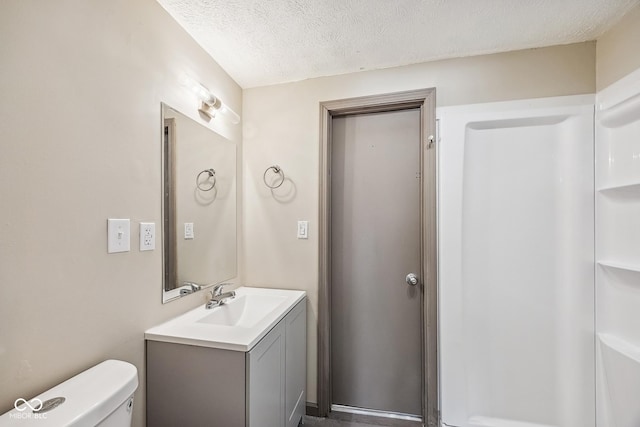 bathroom featuring vanity, toilet, and a textured ceiling