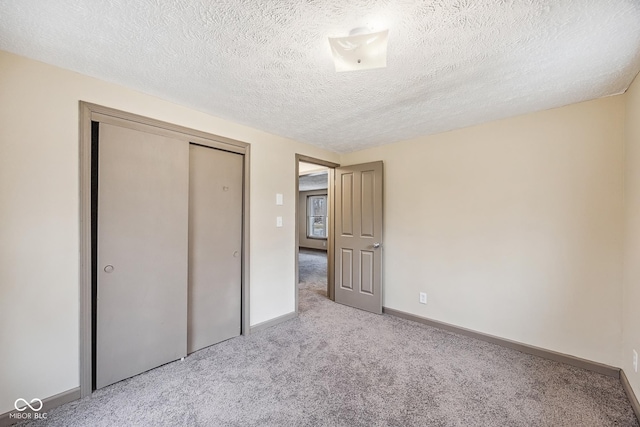 unfurnished bedroom featuring a closet, baseboards, carpet floors, and a textured ceiling