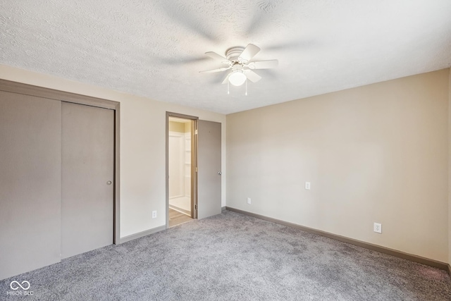 unfurnished bedroom with ceiling fan, baseboards, carpet floors, a closet, and a textured ceiling