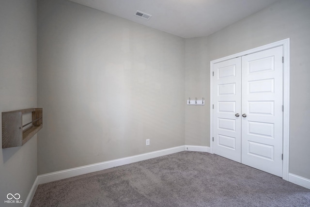 unfurnished bedroom featuring a closet, visible vents, baseboards, and carpet floors