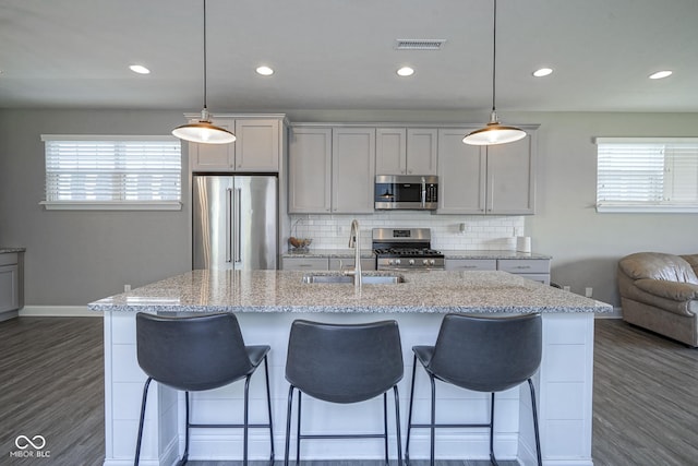 kitchen with dark wood-style flooring, visible vents, appliances with stainless steel finishes, and a sink