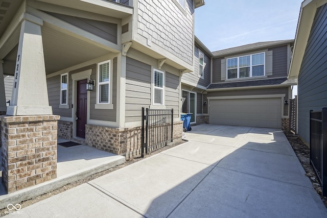 view of home's exterior featuring brick siding, concrete driveway, an attached garage, and fence