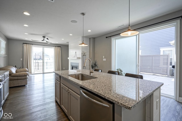 kitchen with dishwasher, a glass covered fireplace, open floor plan, and a sink