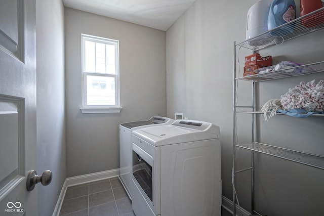 laundry room featuring washer and dryer, laundry area, dark tile patterned floors, and baseboards