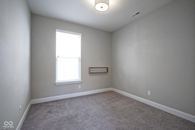 spare room with carpet, baseboards, and visible vents