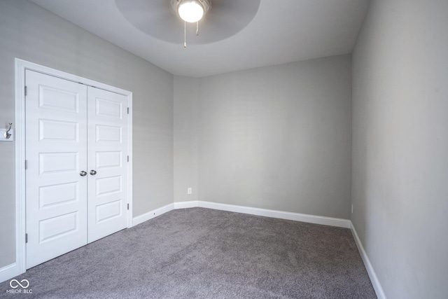 carpeted spare room with baseboards and ceiling fan