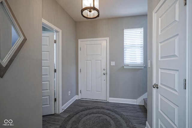 foyer entrance featuring dark wood-type flooring and baseboards