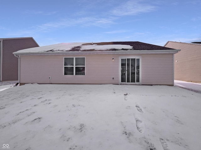 view of snow covered back of property