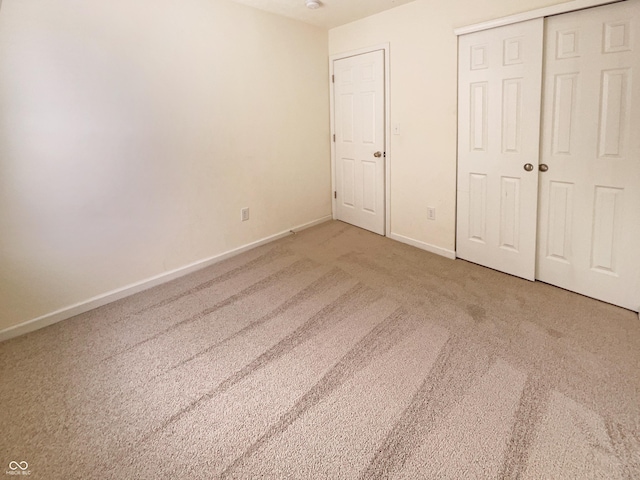 unfurnished bedroom featuring carpet, a closet, and baseboards