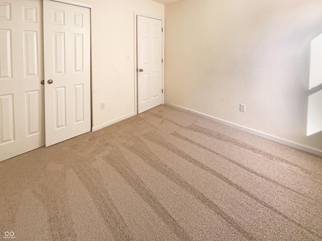 unfurnished bedroom featuring a closet, baseboards, and carpet flooring