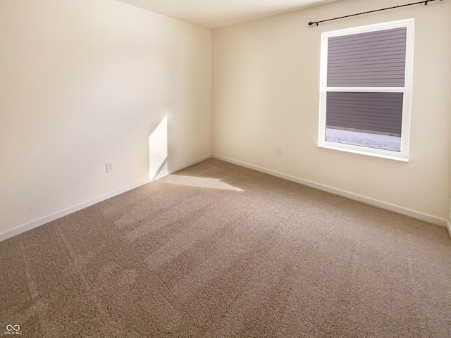 empty room featuring carpet flooring and baseboards