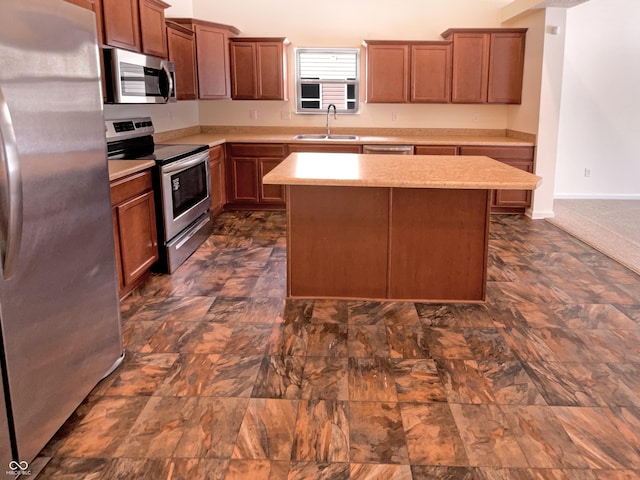 kitchen with a center island, baseboards, light countertops, appliances with stainless steel finishes, and a sink