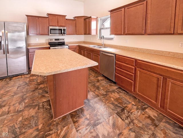 kitchen with a center island, light countertops, brown cabinetry, stainless steel appliances, and a sink