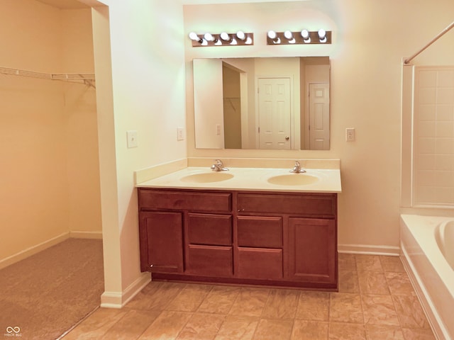 full bath featuring double vanity, a bathing tub, baseboards, and a sink