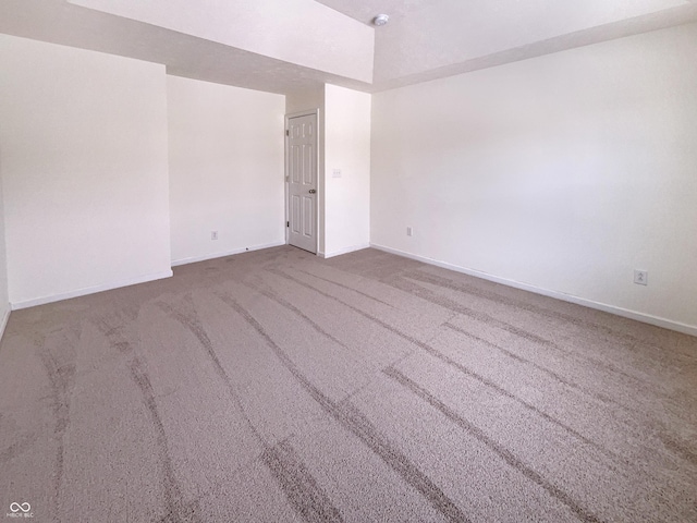 carpeted empty room featuring baseboards