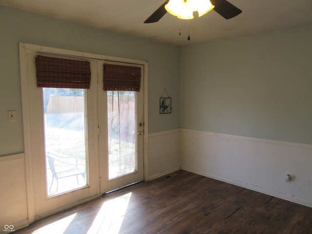 doorway featuring a healthy amount of sunlight, wood finished floors, and wainscoting