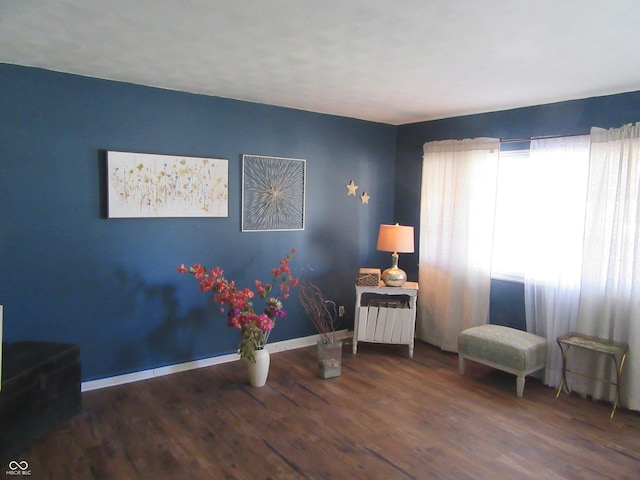 living area featuring baseboards and wood finished floors