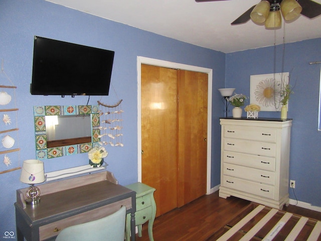 bedroom featuring baseboards, wood finished floors, and a ceiling fan