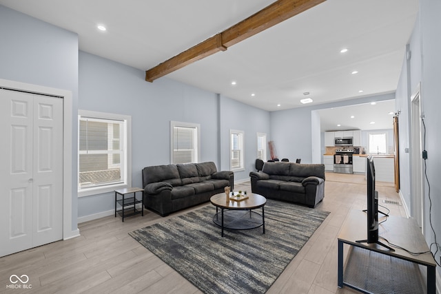 living area featuring recessed lighting, beamed ceiling, baseboards, and light wood-style floors