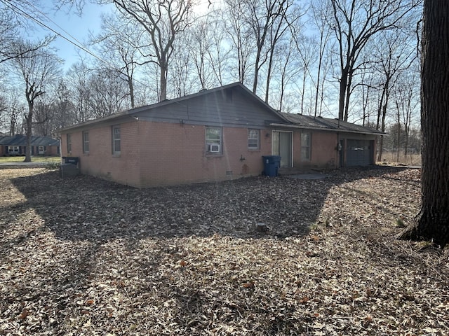 view of home's exterior with crawl space, brick siding, and an attached garage