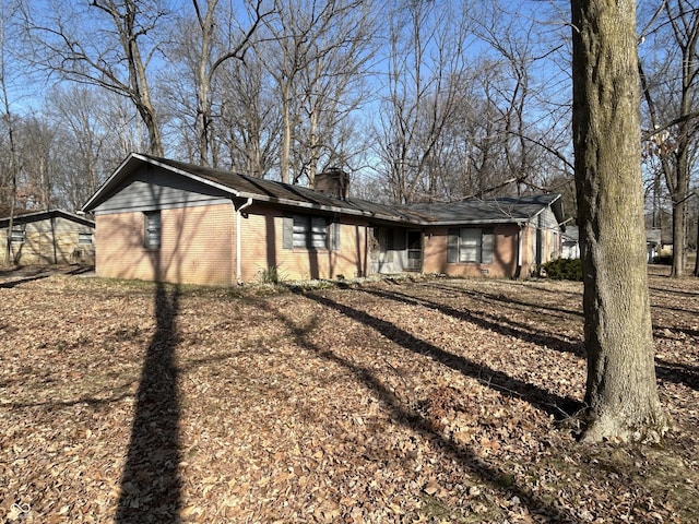 view of home's exterior with brick siding and a chimney