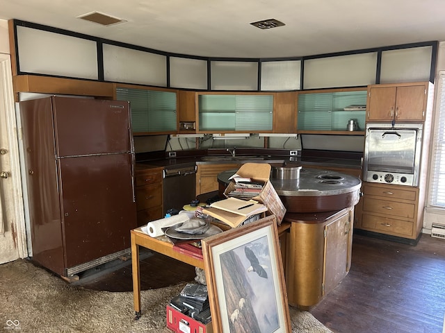 kitchen featuring dark countertops, visible vents, freestanding refrigerator, and dishwashing machine