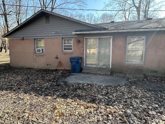 rear view of property with brick siding and crawl space