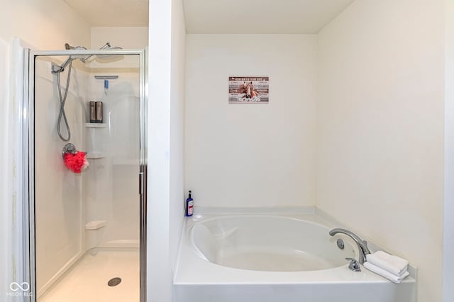 full bathroom featuring a garden tub and a shower stall