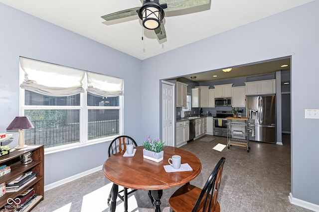 dining area featuring baseboards and ceiling fan