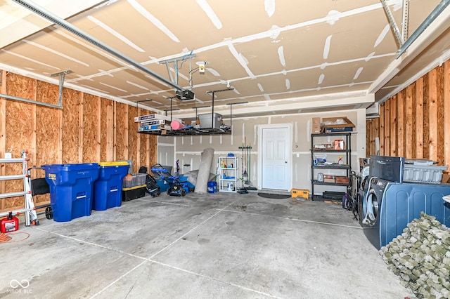 garage with a garage door opener and wood walls