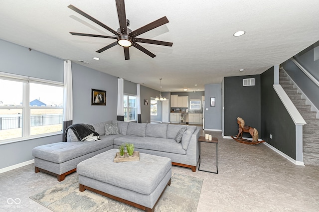 living room featuring visible vents, ceiling fan with notable chandelier, recessed lighting, stairway, and baseboards