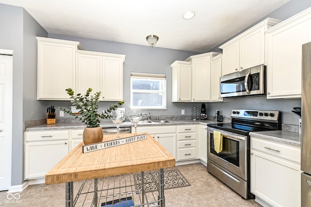kitchen featuring a sink, light countertops, white cabinetry, and stainless steel appliances