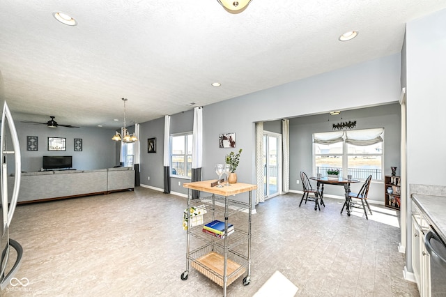 kitchen with recessed lighting, ceiling fan with notable chandelier, a textured ceiling, and baseboards
